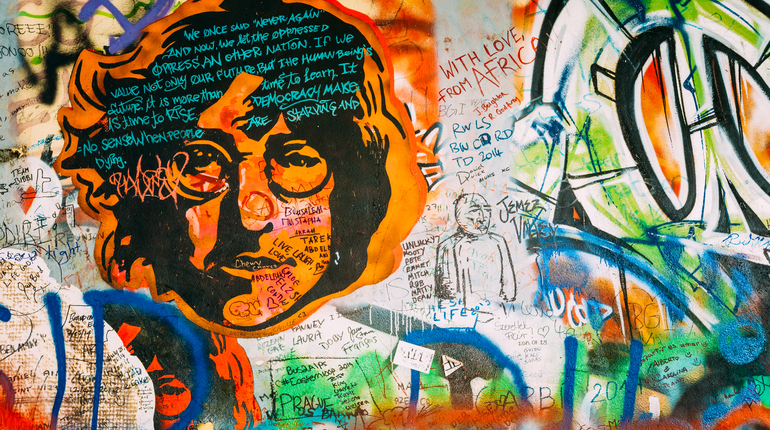 Prague, Czech Republic - October 10, 2014: Famous place in Prague - The John Lennon Wall. Wall is filled with John Lennon inspired graffiti and lyrics from Beatles songs